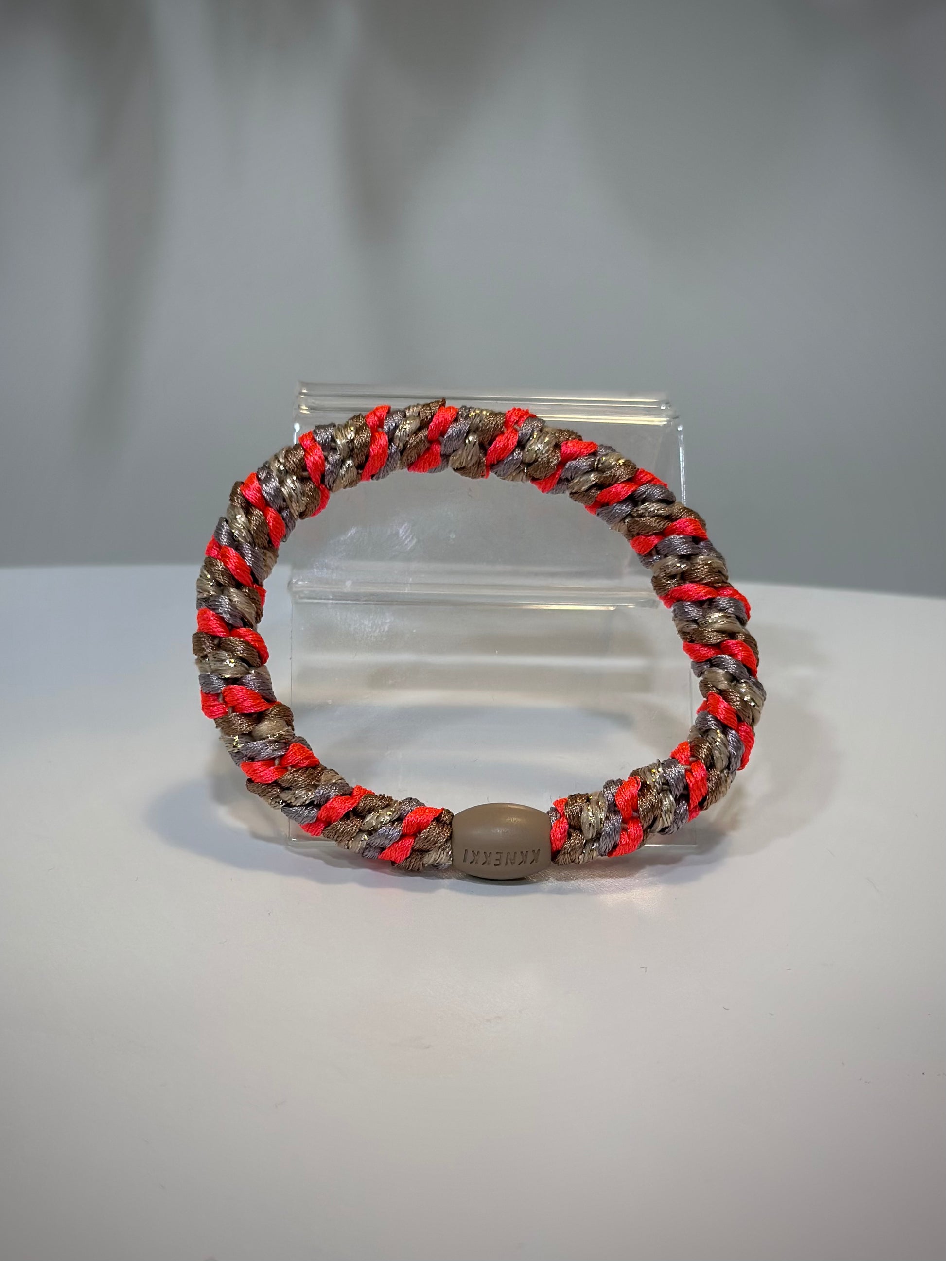 élastique pailleté rose fluo posé sur une table claire