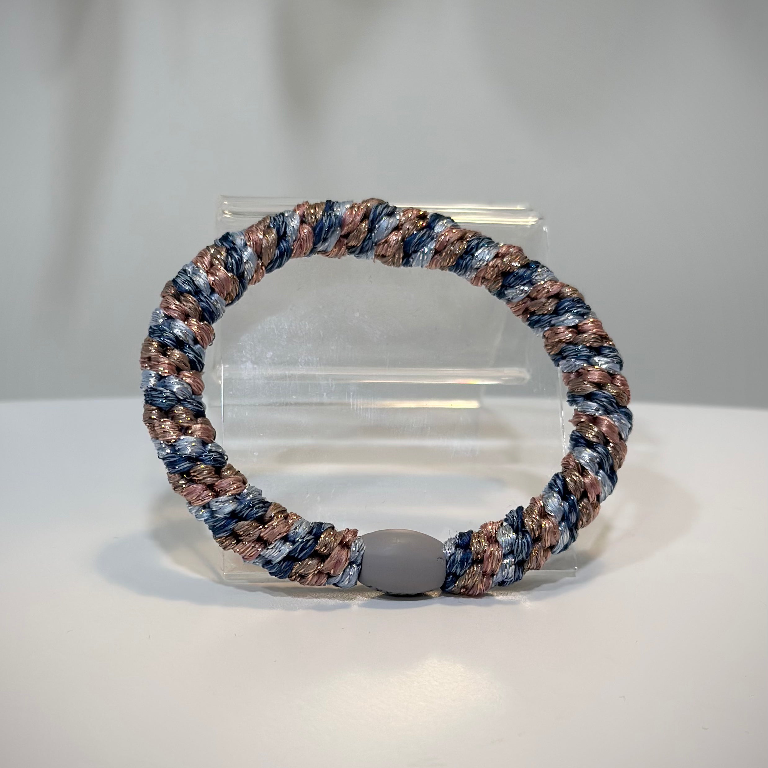 élastique rose et bleu pailleté posé sur une table claire