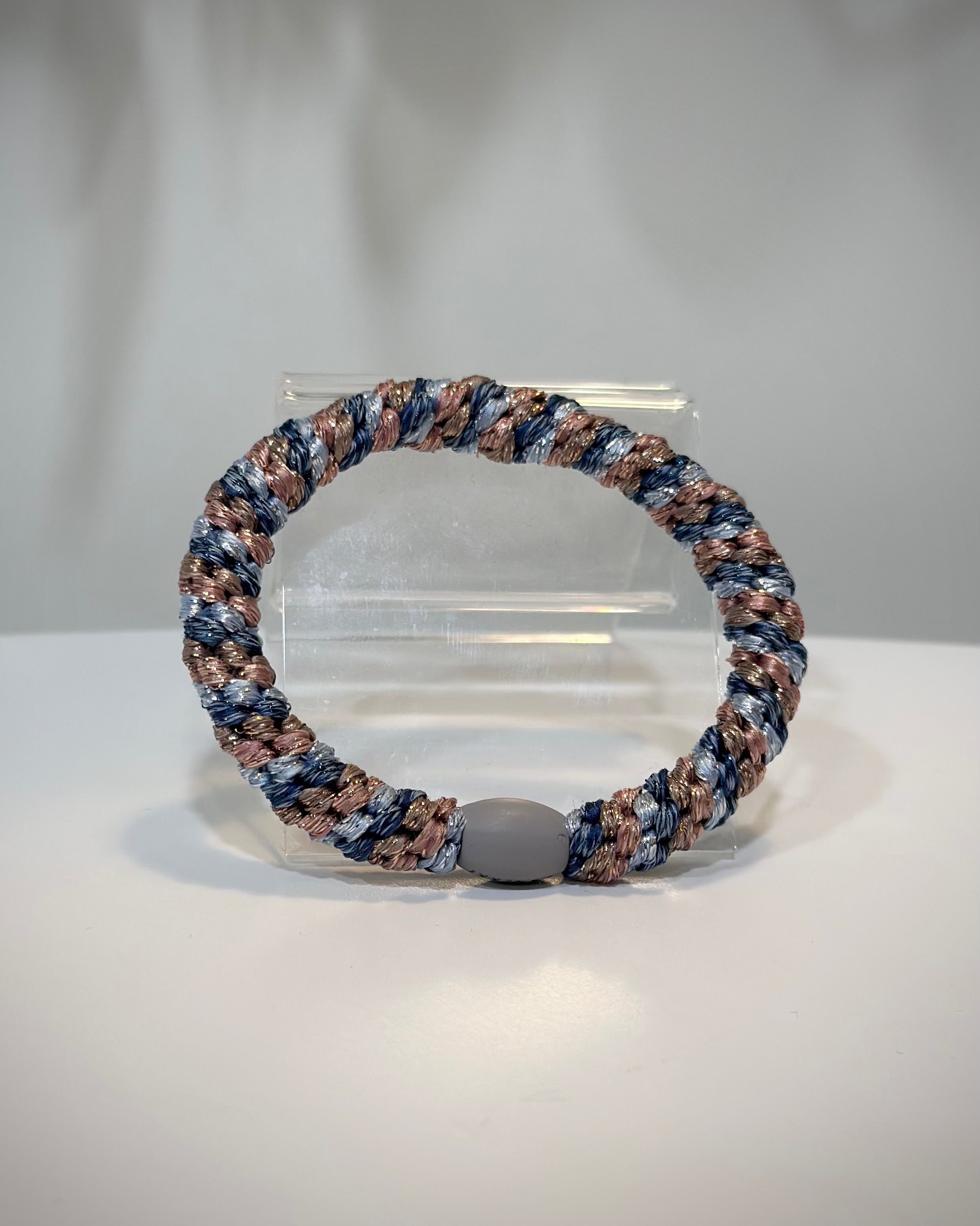 élastique rose et bleu pailleté posé sur une table claire