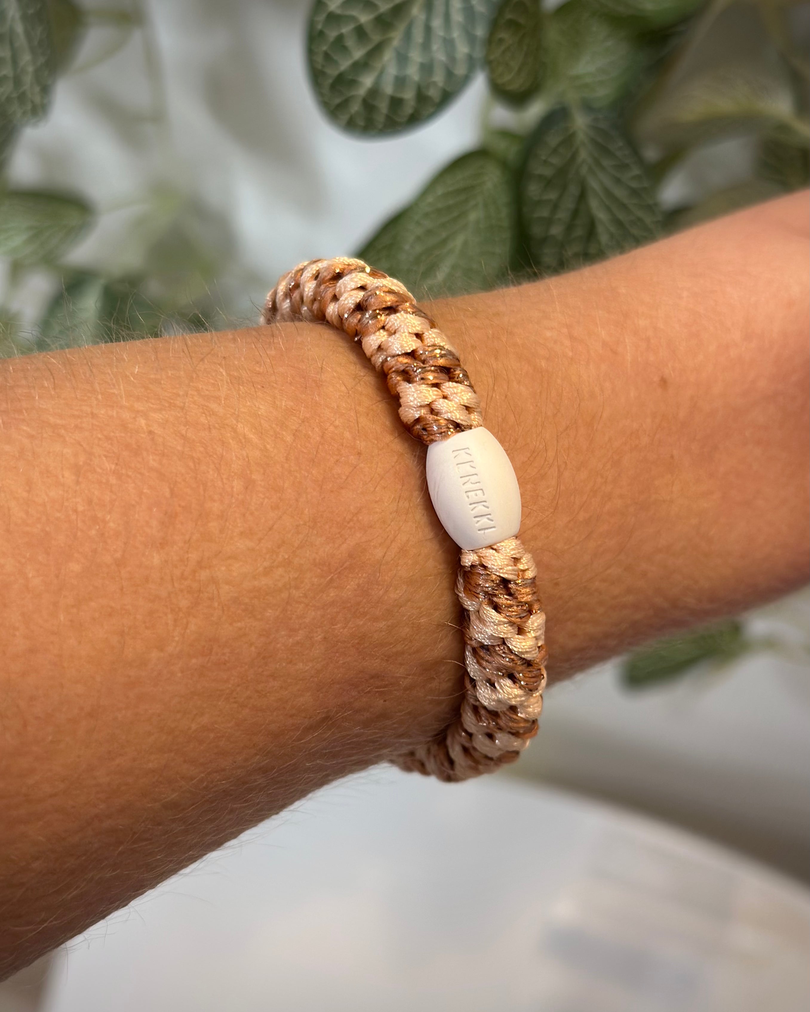 élastique rose gold orange pailleté porté en bracelet sur poignet femme