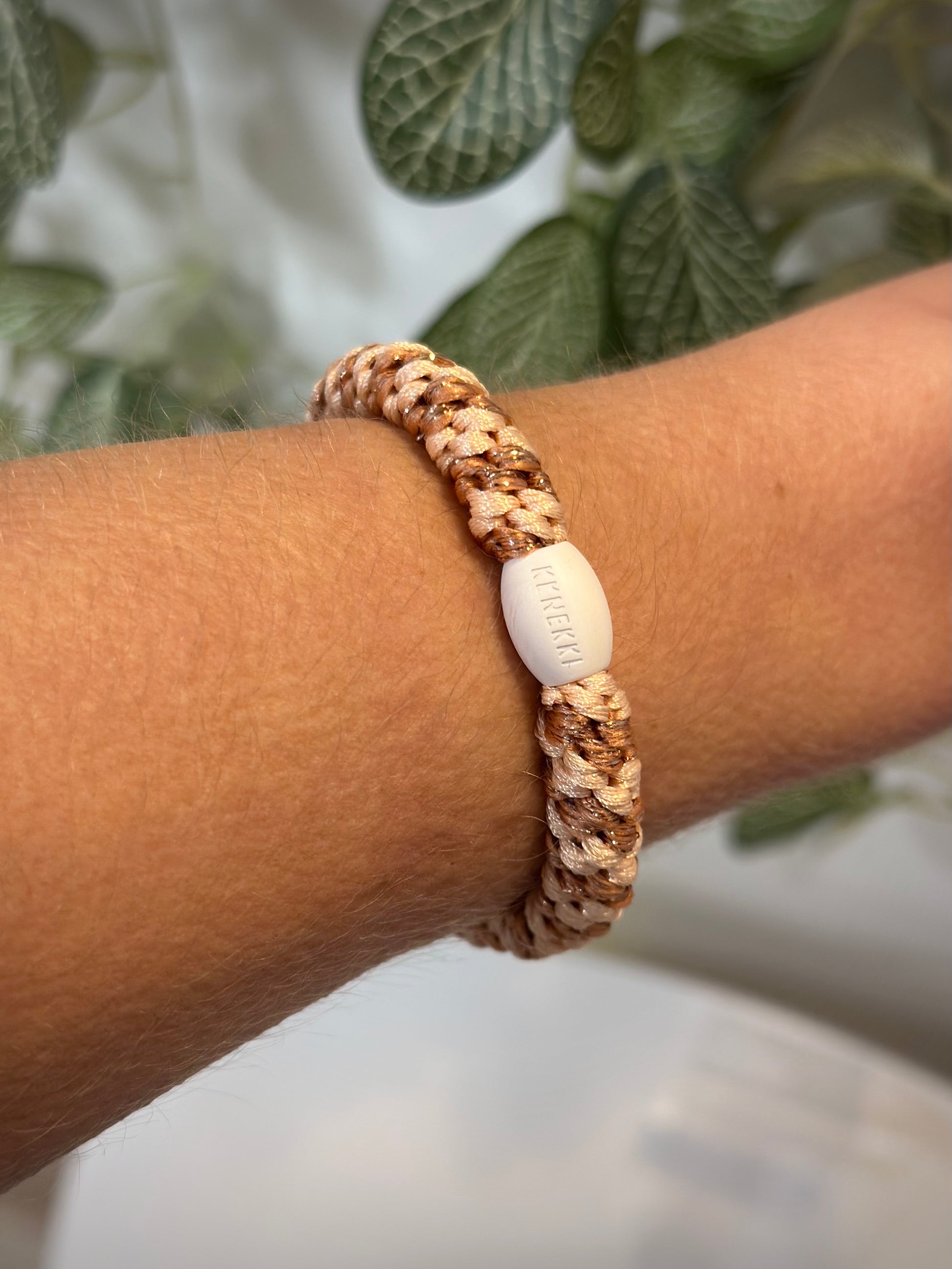 élastique rose gold orange pailleté porté en bracelet sur poignet femme