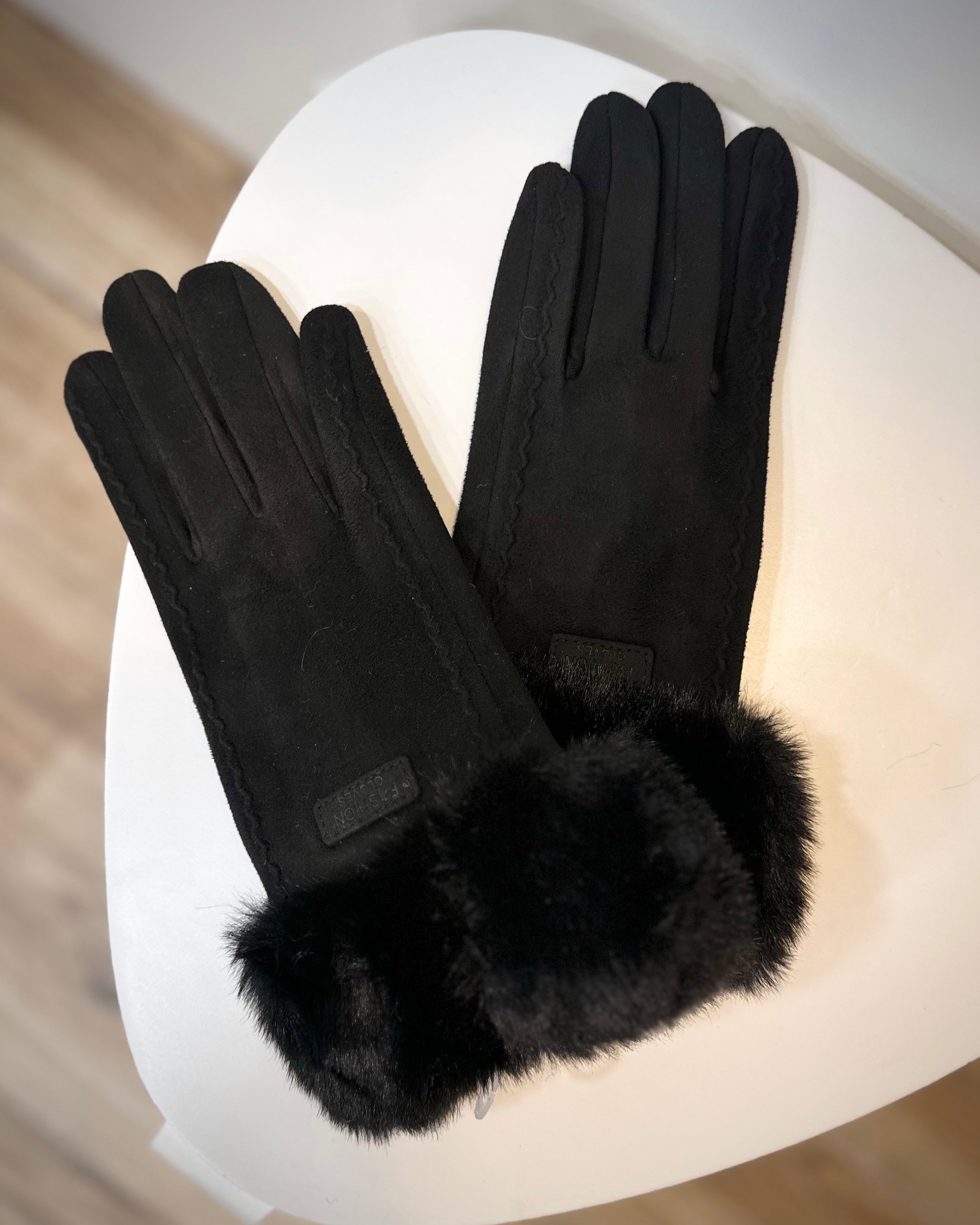Gants noirs posés sur une surface en bois