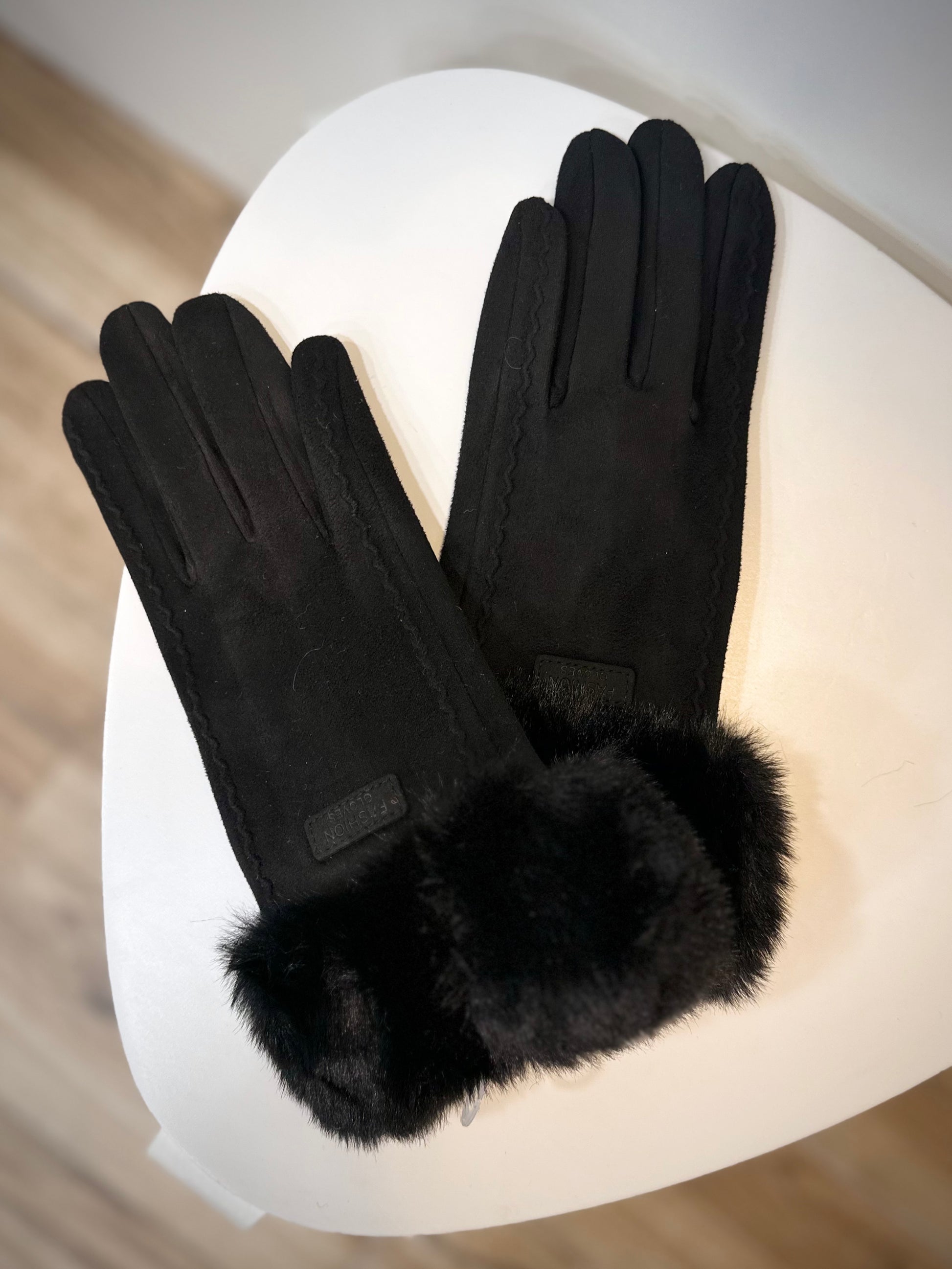Gants noirs posés sur une surface en bois