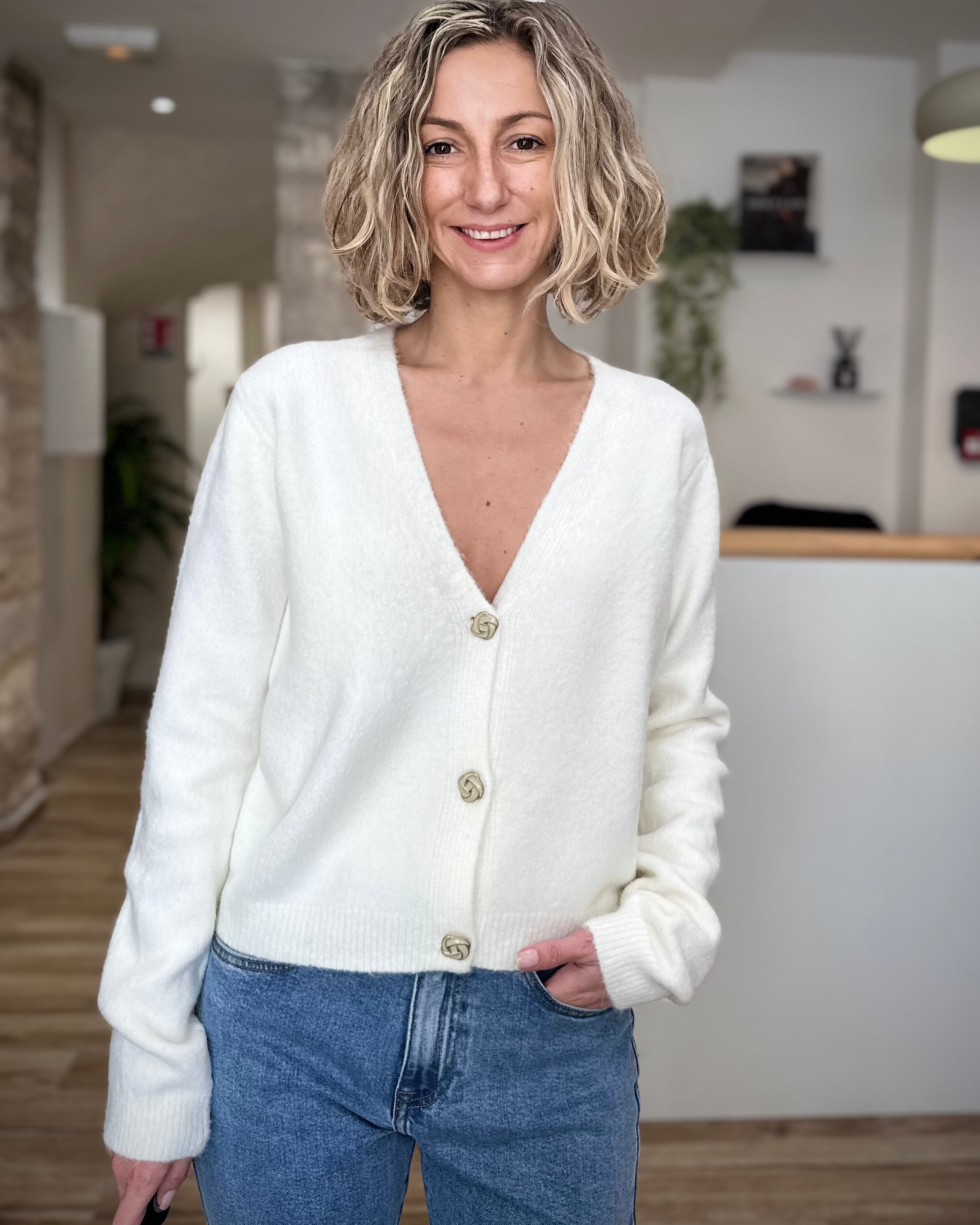 Femme portant un gilet blanc boutonné devant