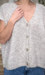 Gros plan sur l’ouverture boutonnée du cardigan Savant