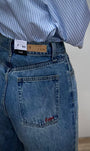 Détail logo brodé rouge poche arrière jean