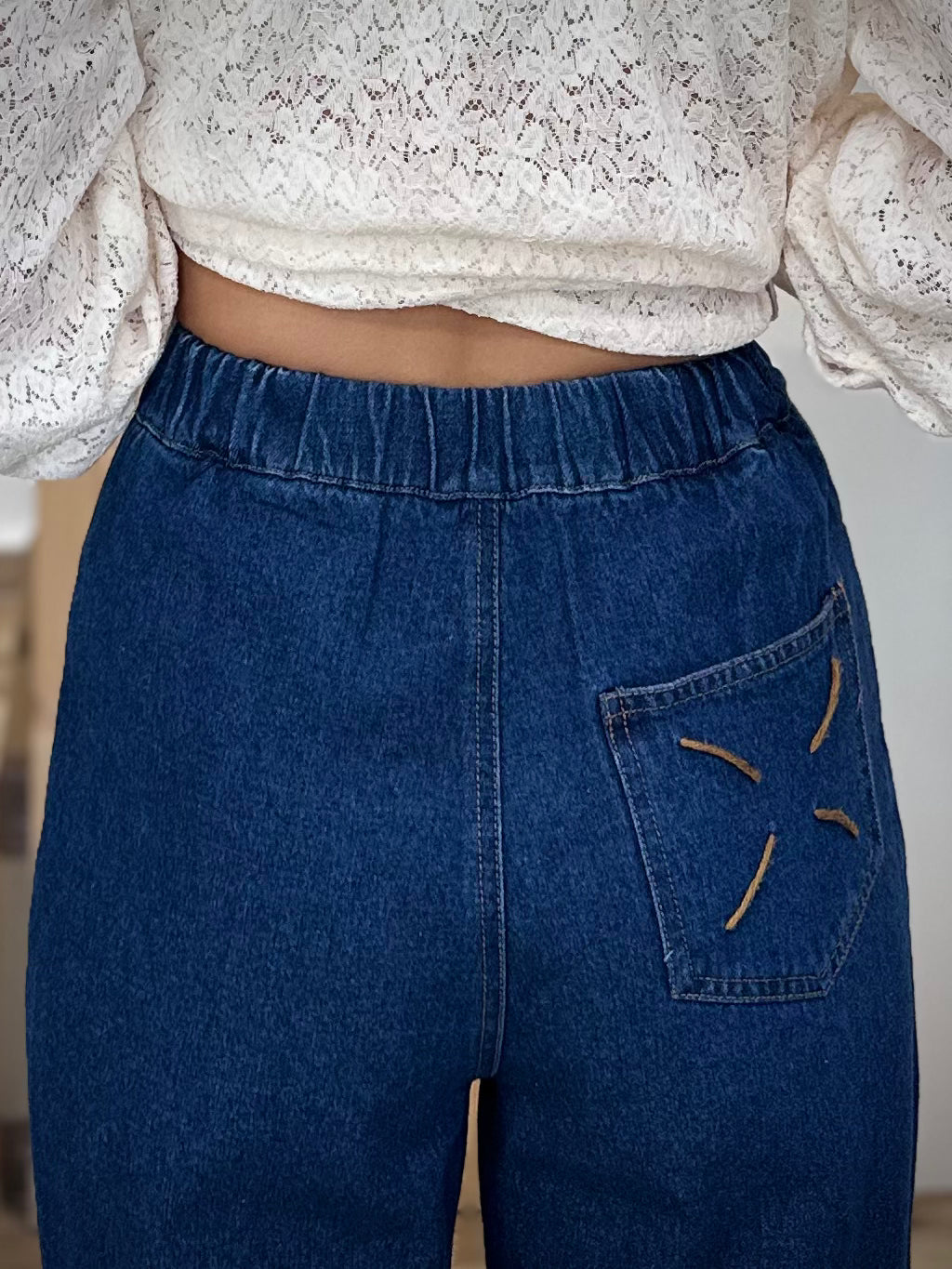 Détail de la croix brodée sur la poche arrière du jean