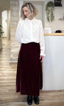 Femme portant une jupe midi en velours bordeaux casual chic