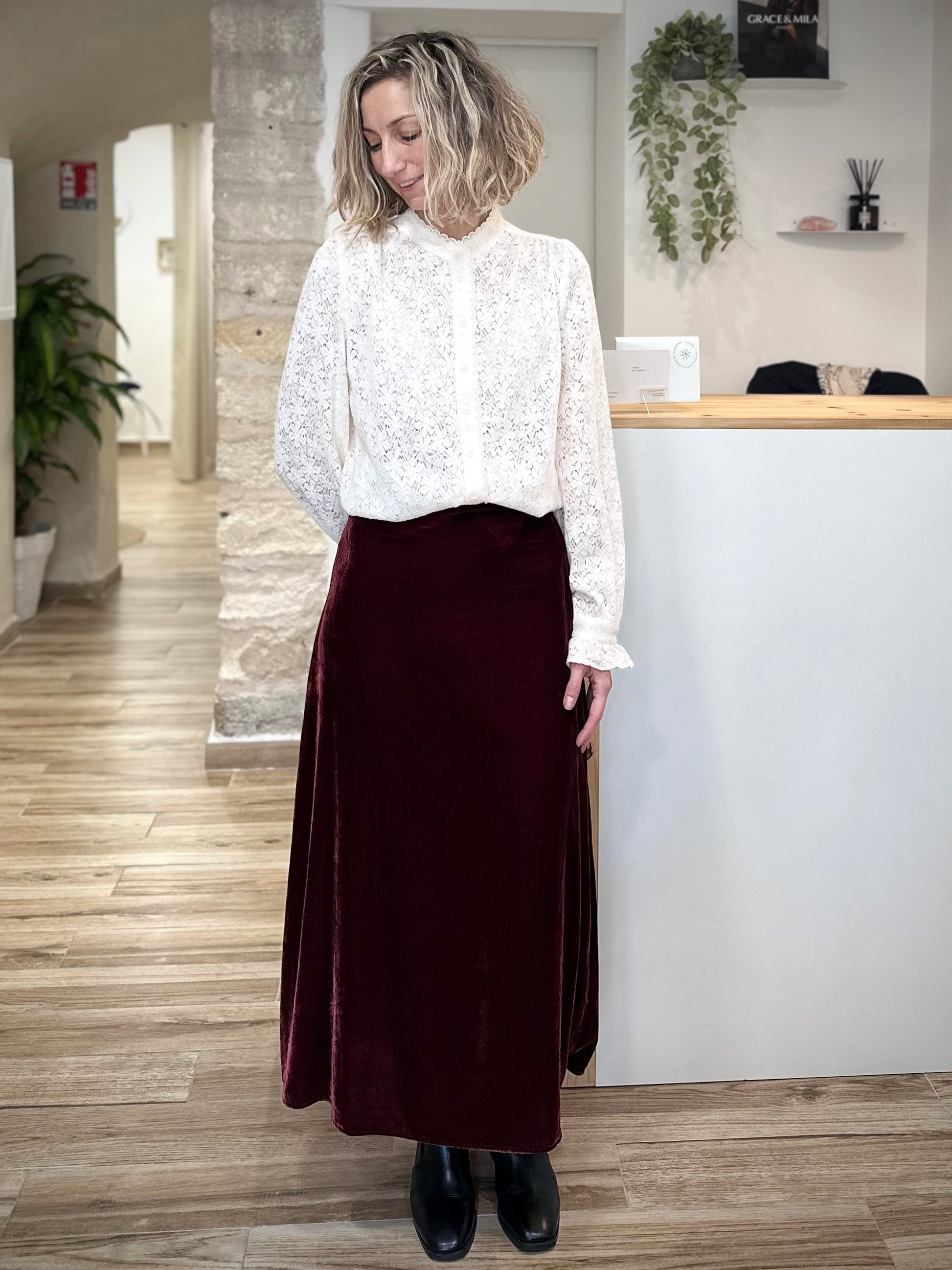 Femme portant une jupe midi en velours bordeaux casual chic