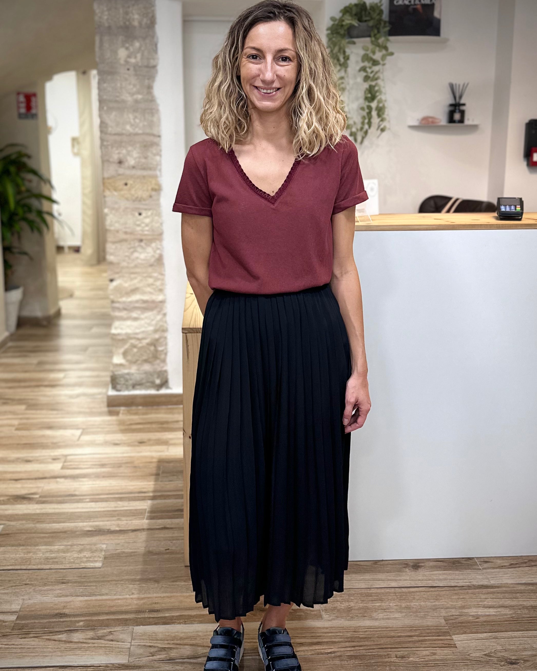 Look casual chic avec jupe noire plissée et baskets 