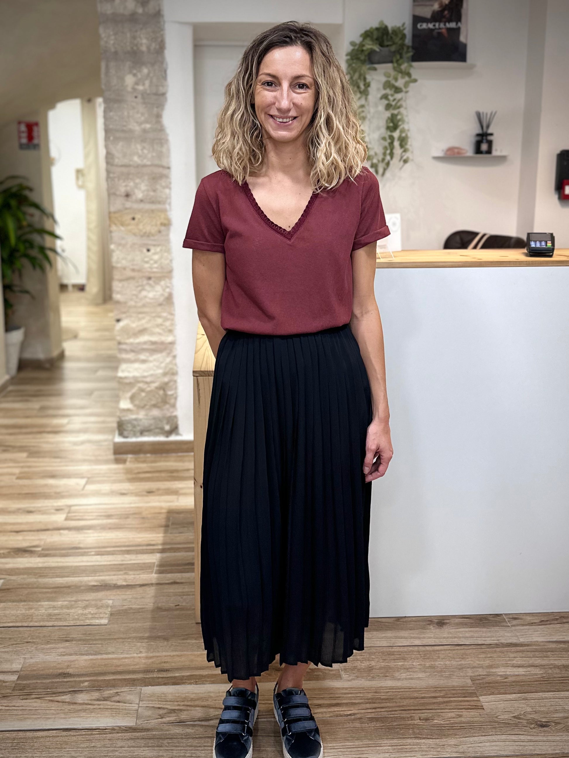Look casual chic avec jupe noire plissée et baskets 