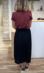 Silhouette féminine de dos en jupe midi noire casual chic