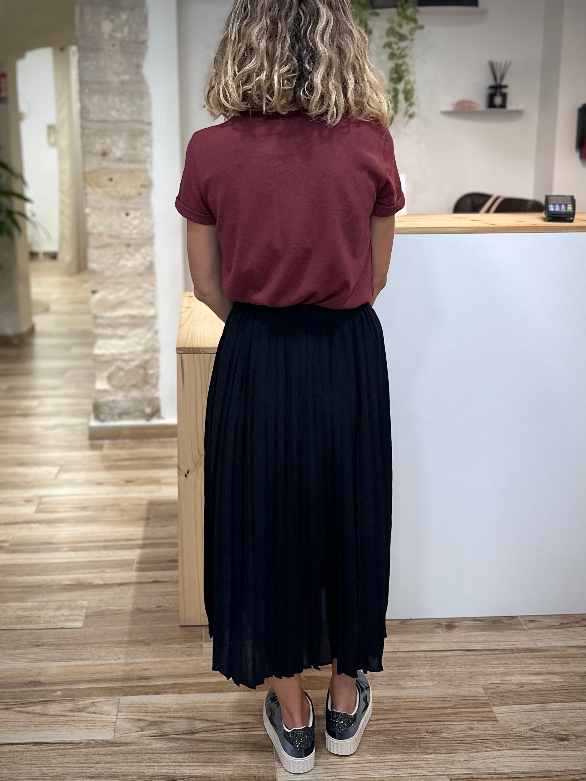 Silhouette féminine de dos en jupe midi noire casual chic