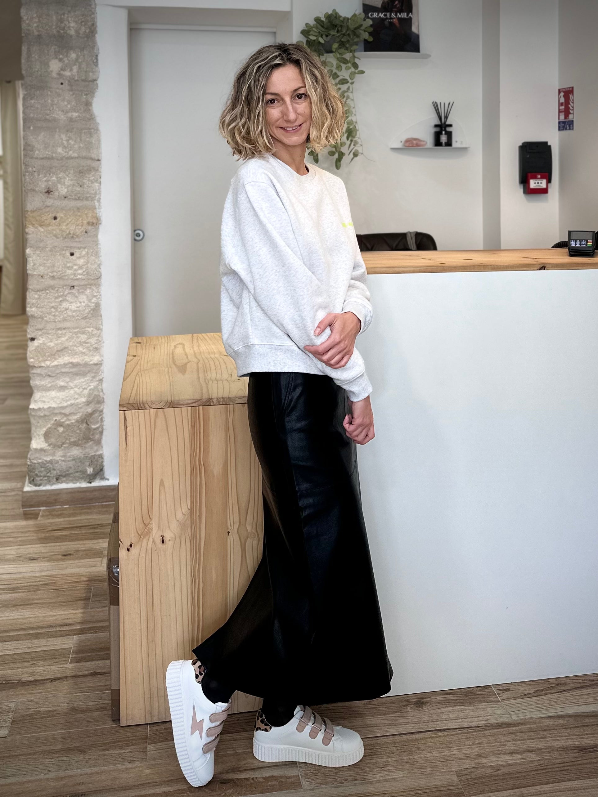 Femme portant une jupe midi en simili cuir noir