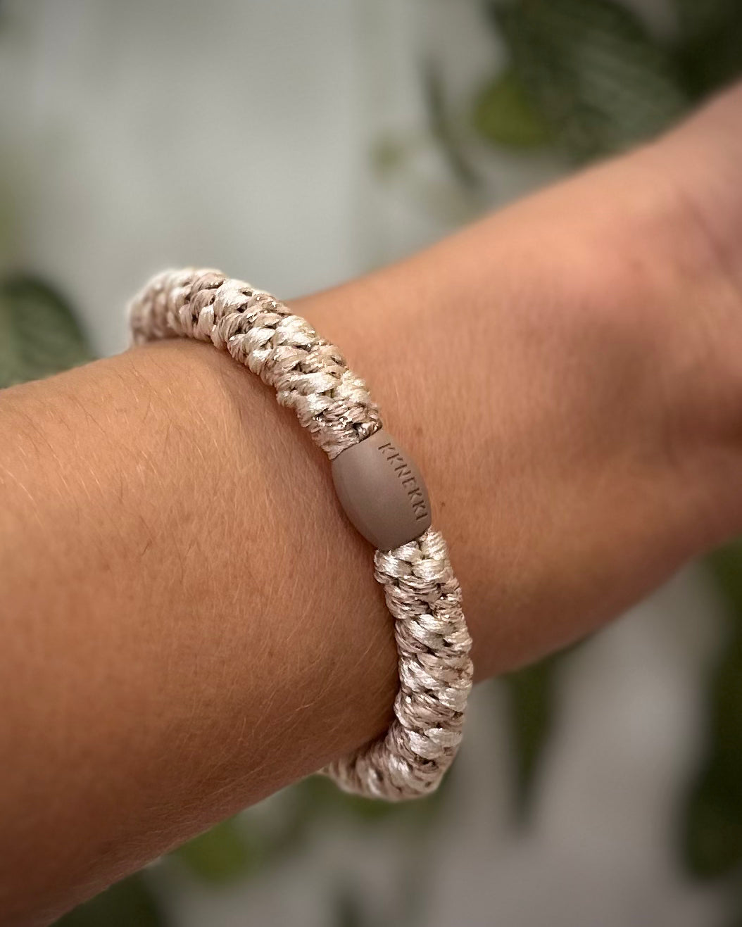 Elastique Kknekki pailleté ivoire beige porté comme bracelet sur poignet femme