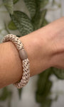 Elastique Kknekki beige pailleté porté comme bracelet sur poignet femme