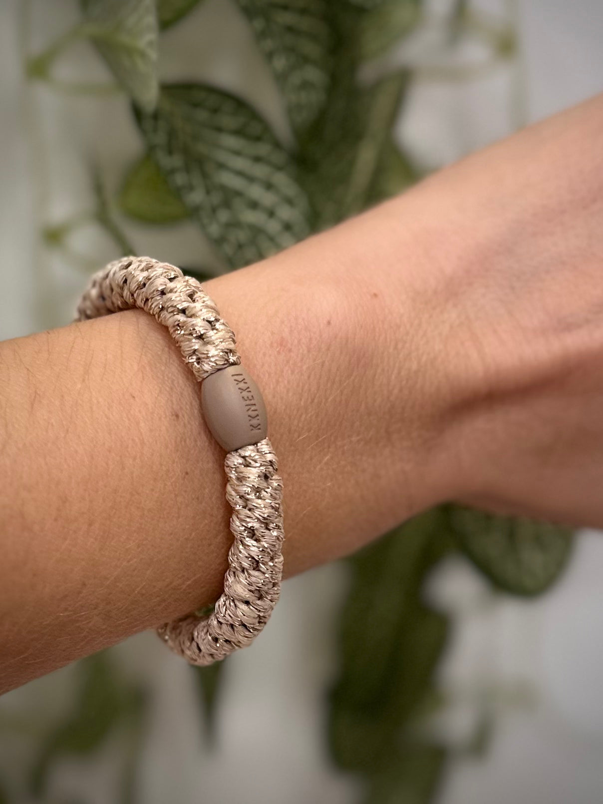 Elastique Kknekki beige pailleté porté comme bracelet sur poignet femme