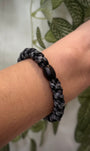 Elastique Kknekki gris clair et gris charbon pailleté porté comme bracelet sur poignet femme