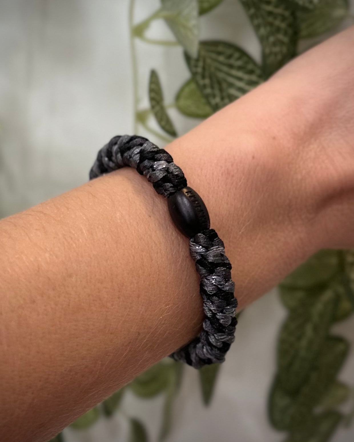 Elastique Kknekki gris clair et gris charbon pailleté porté comme bracelet sur poignet femme