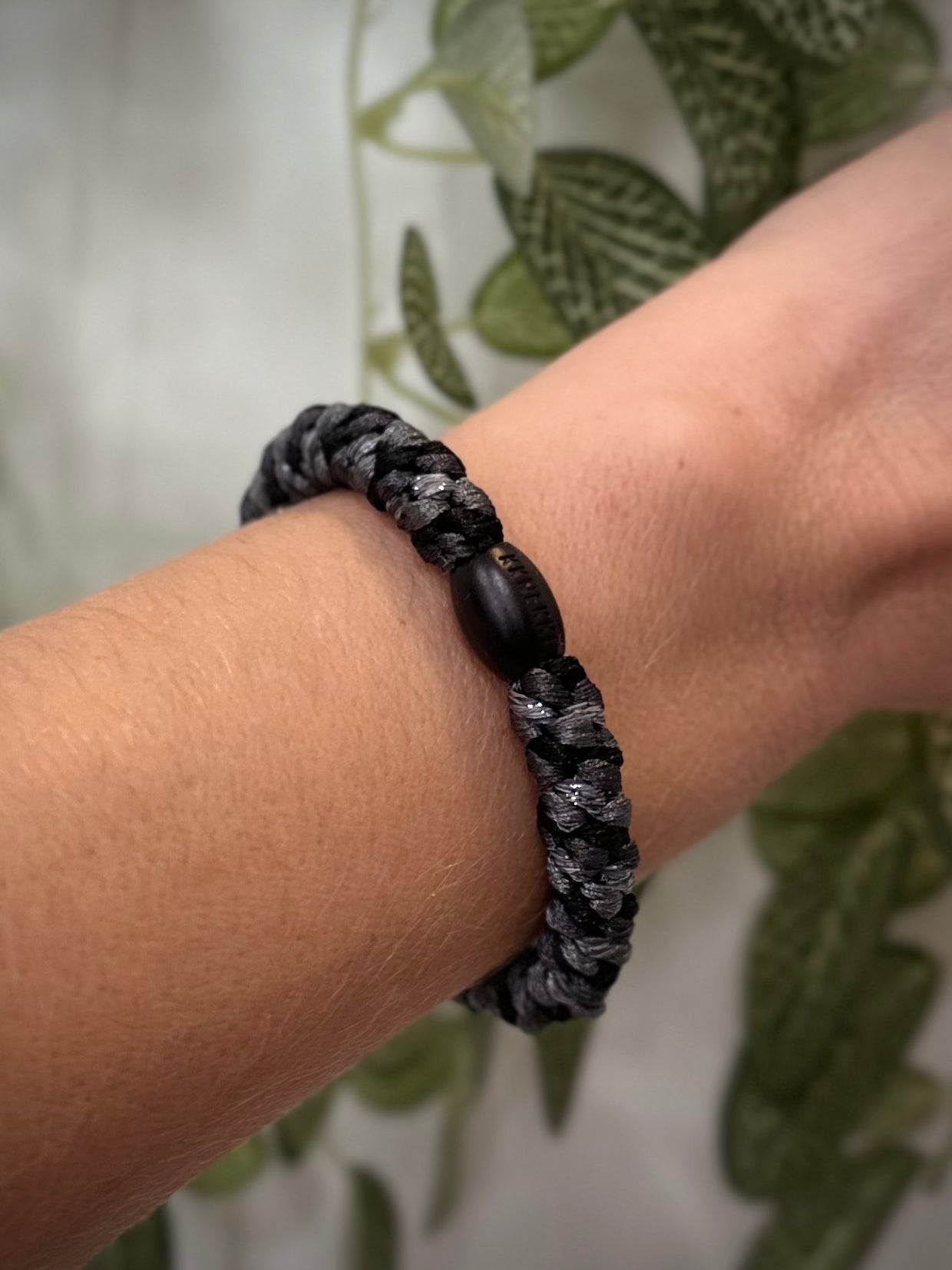 Elastique Kknekki gris clair et gris charbon pailleté porté comme bracelet sur poignet femme