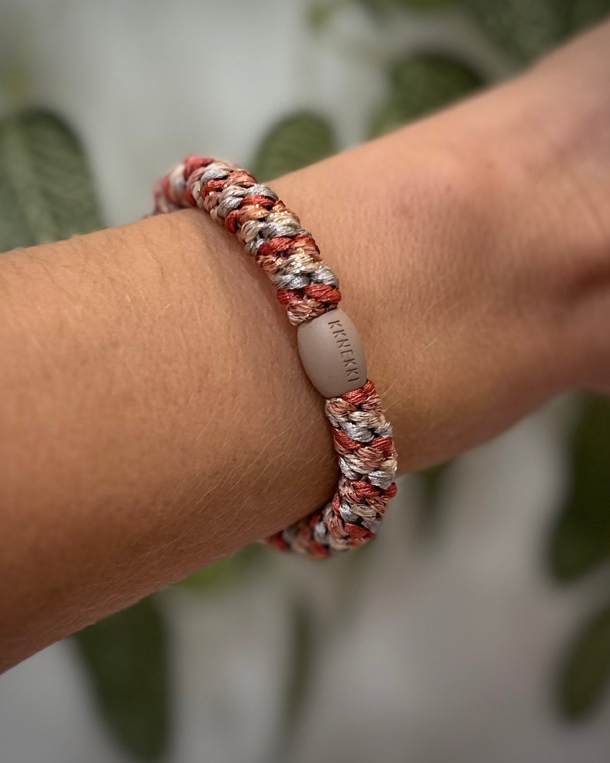 Elastique Kknekki pailleté gris terracotta porté comme bracelet sur poignet femme