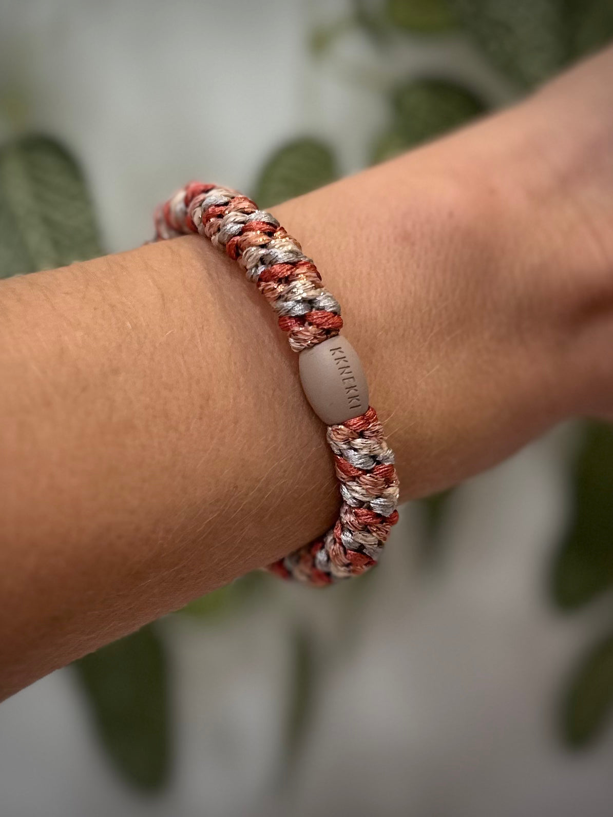 Elastique Kknekki pailleté gris terracotta porté comme bracelet sur poignet femme