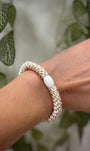 Elastique Kknekki ivoire porté comme bracelet sur poignet femme