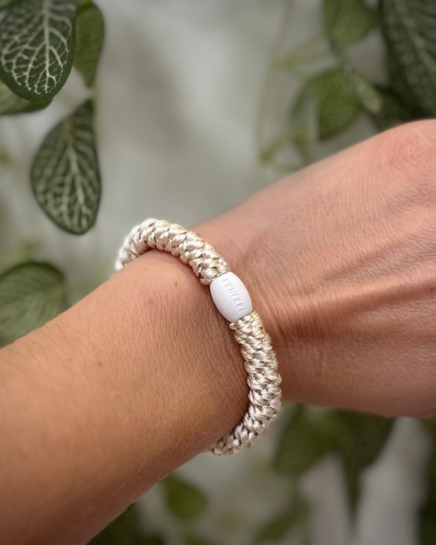 Elastique Kknekki ivoire porté comme bracelet sur poignet femme