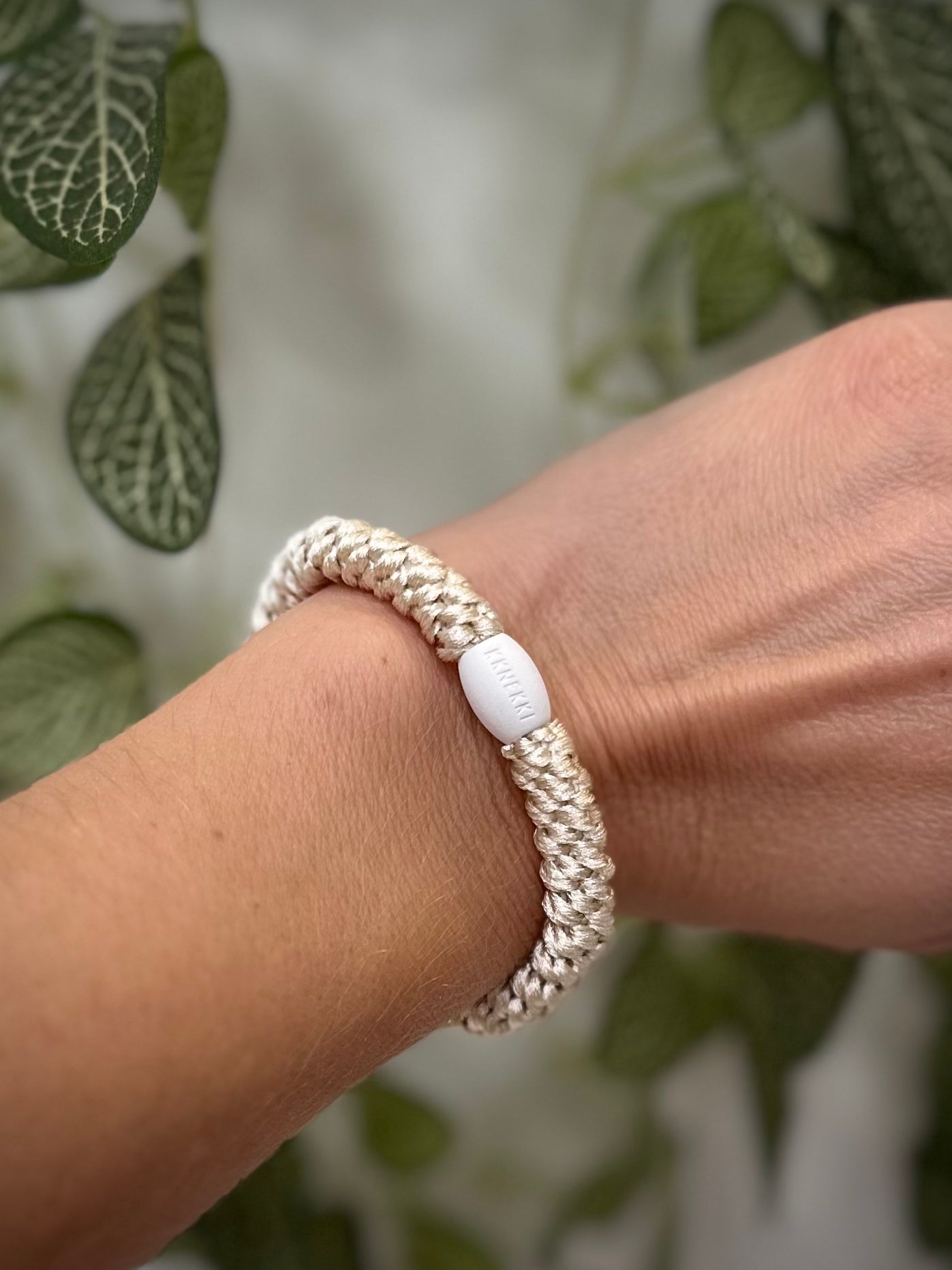 Elastique Kknekki ivoire porté comme bracelet sur poignet femme