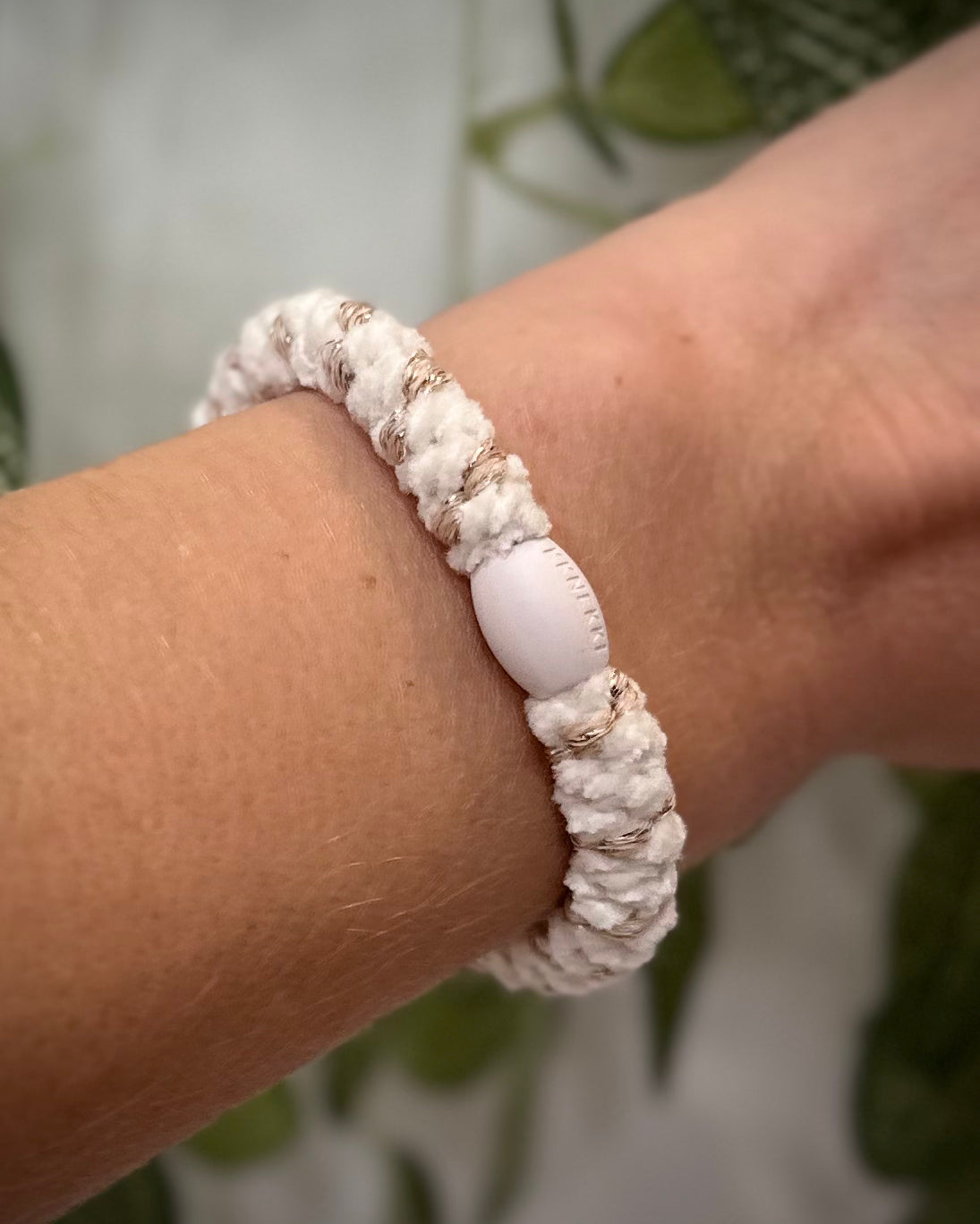 Elastique Kknekki rayures dorées porté comme bracelet sur poignet femme