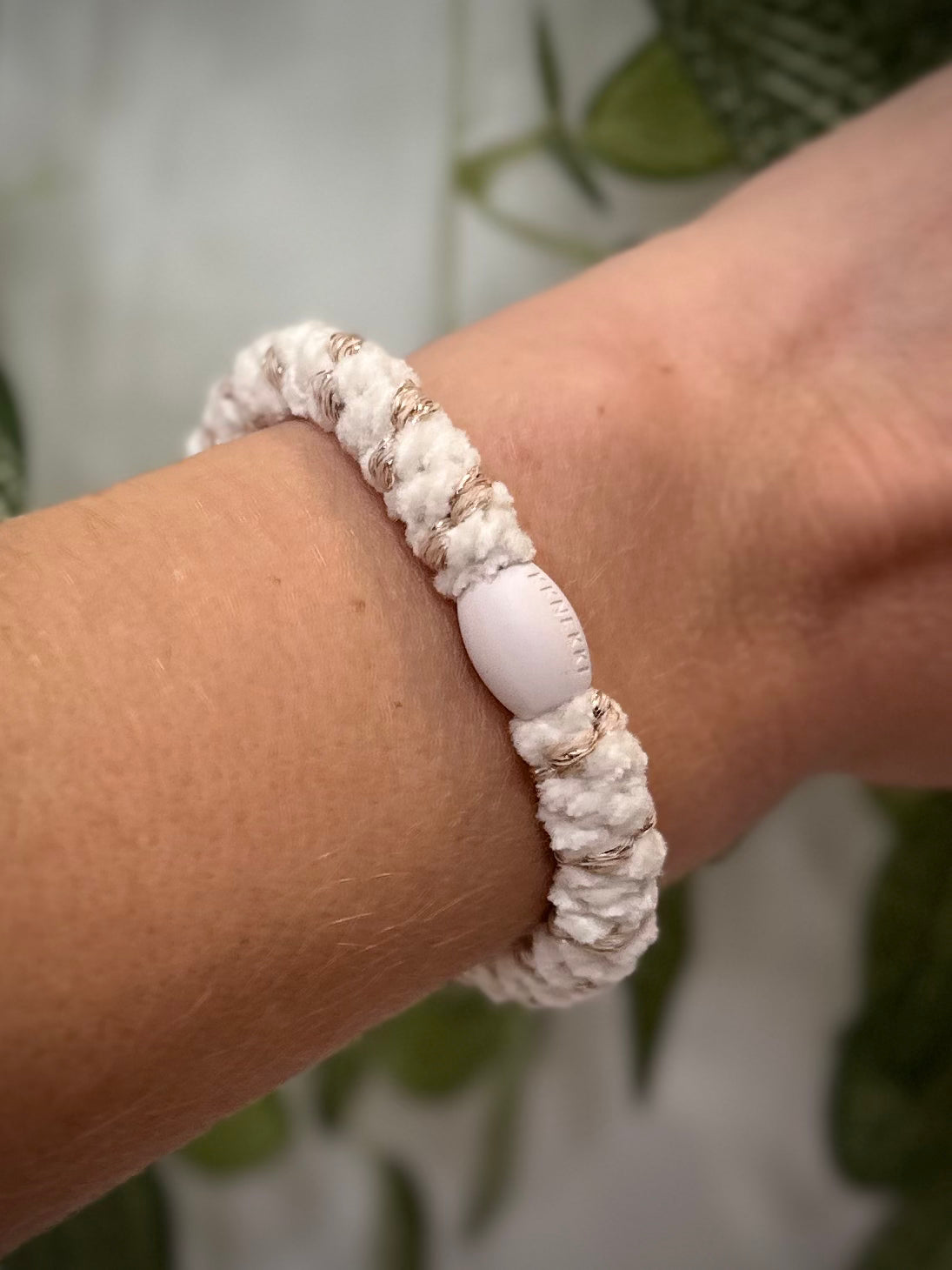 Elastique Kknekki rayures dorées porté comme bracelet sur poignet femme