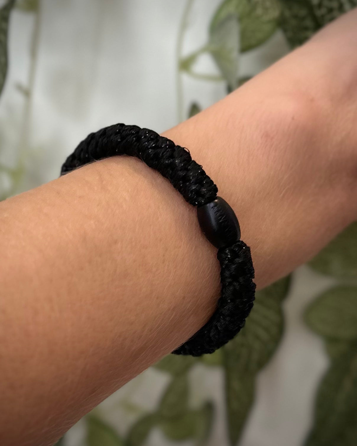 Elastique Kknekki noir pailleté porté comme bracelet sur poignet femme