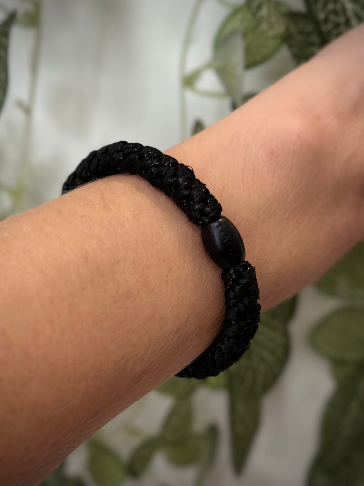 Elastique Kknekki noir pailleté porté comme bracelet sur poignet femme