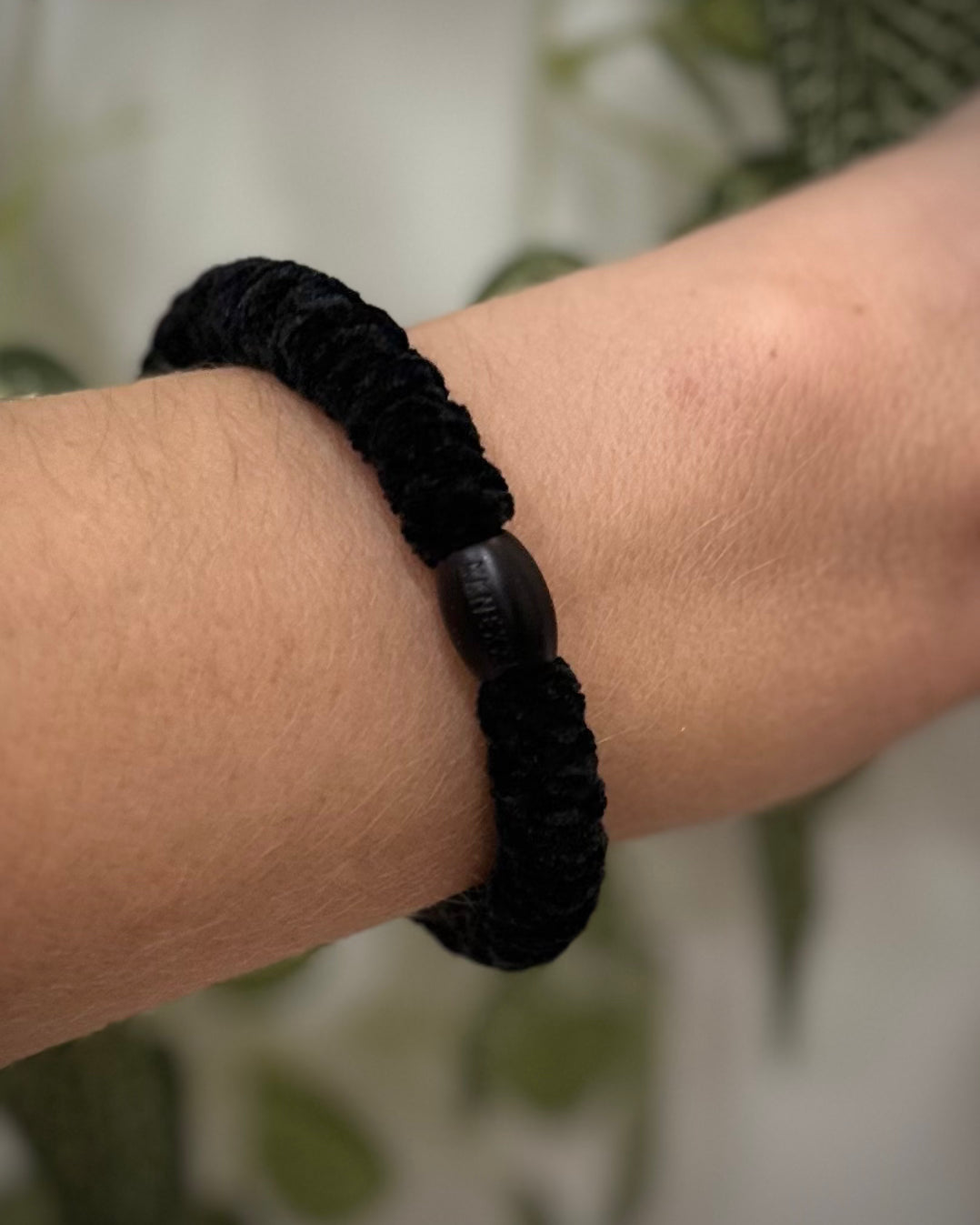 Elastique Kknekki noir velours porté comme bracelet sur poignet femme
