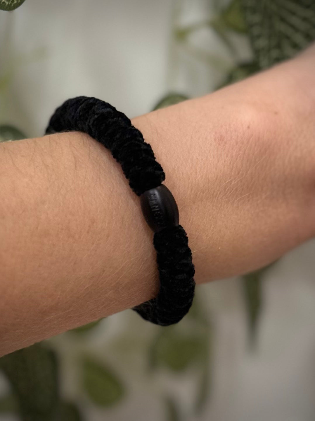 Elastique Kknekki noir velours porté comme bracelet sur poignet femme