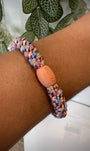 Bracelet Kknekki pêche et bleu ciel au poignet
