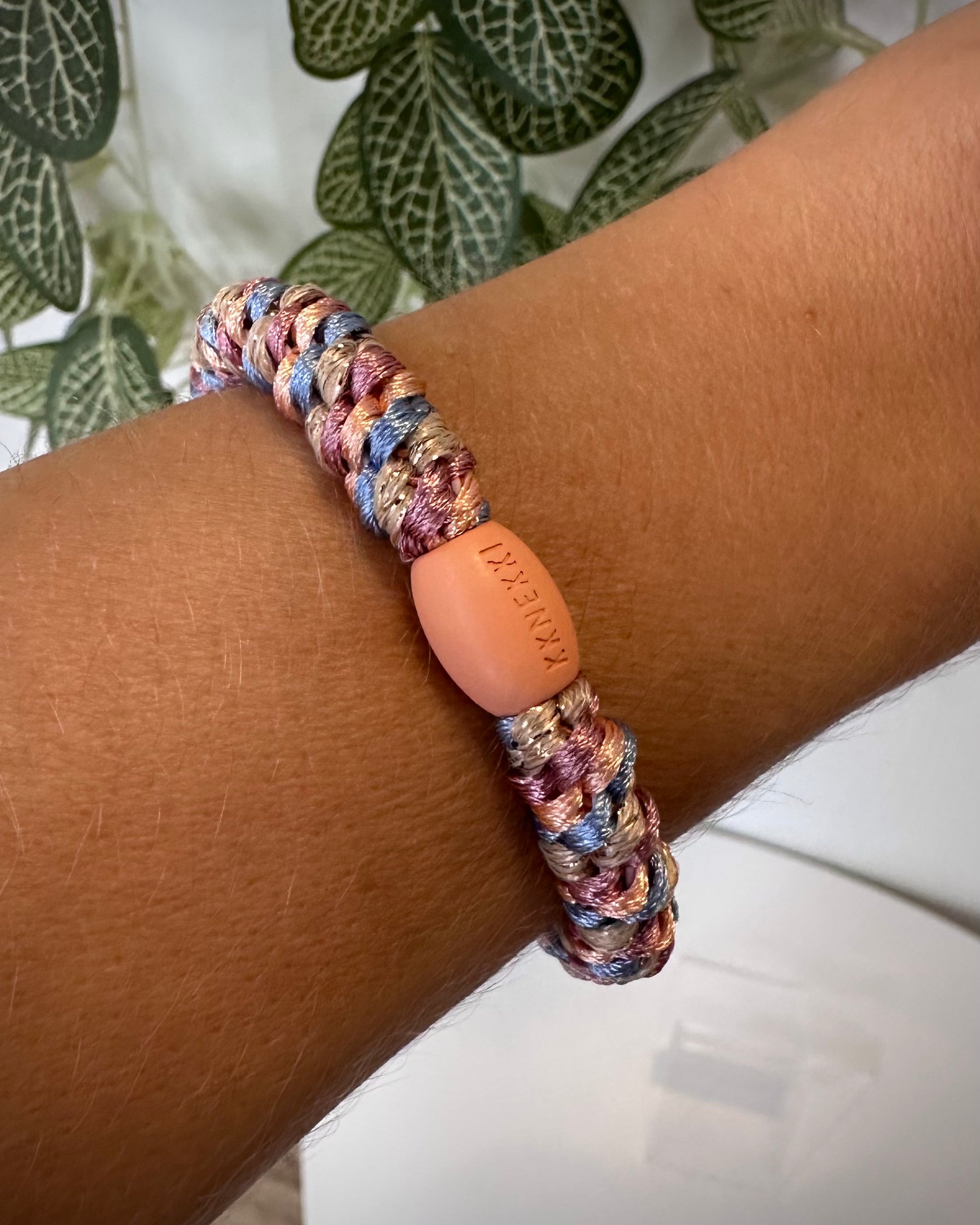 Bracelet Kknekki pêche et bleu ciel au poignet