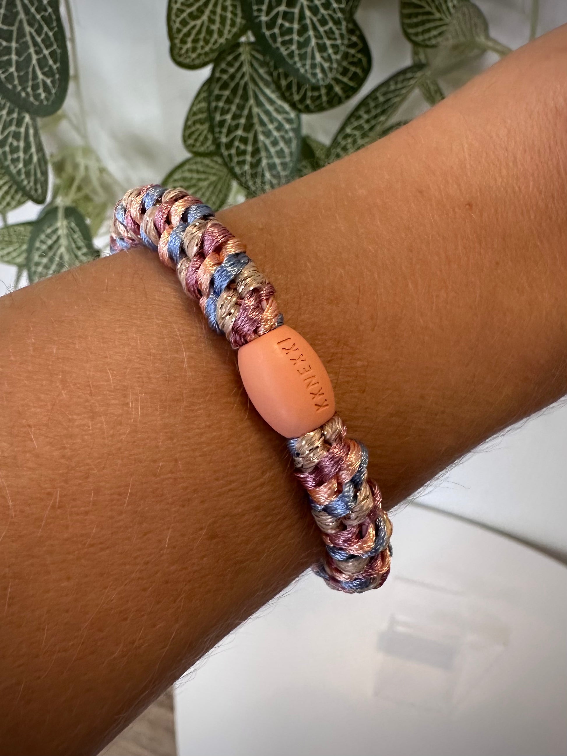 Bracelet Kknekki pêche et bleu ciel au poignet