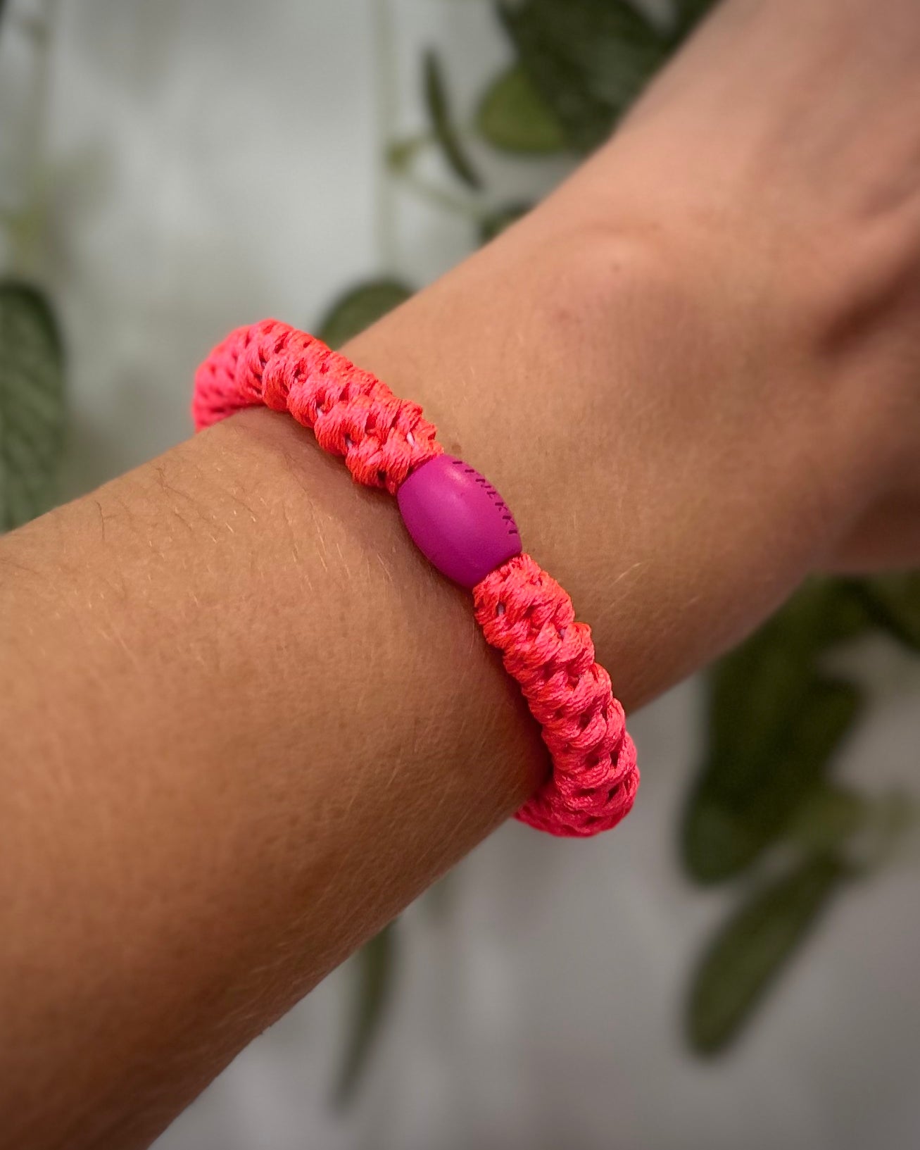 Elastique Kknekki rose néon porté comme bracelet sur poignet femme