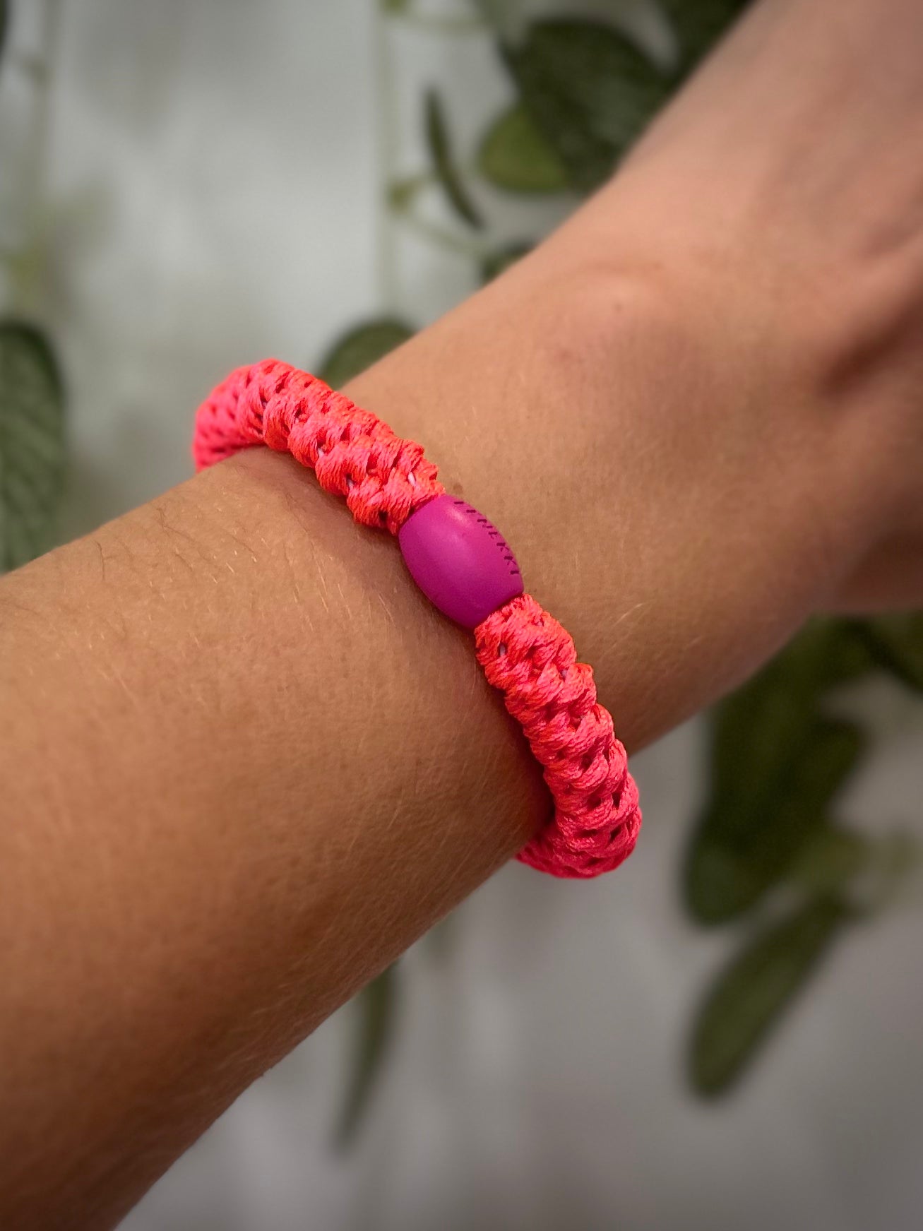 Elastique Kknekki rose néon porté comme bracelet sur poignet femme