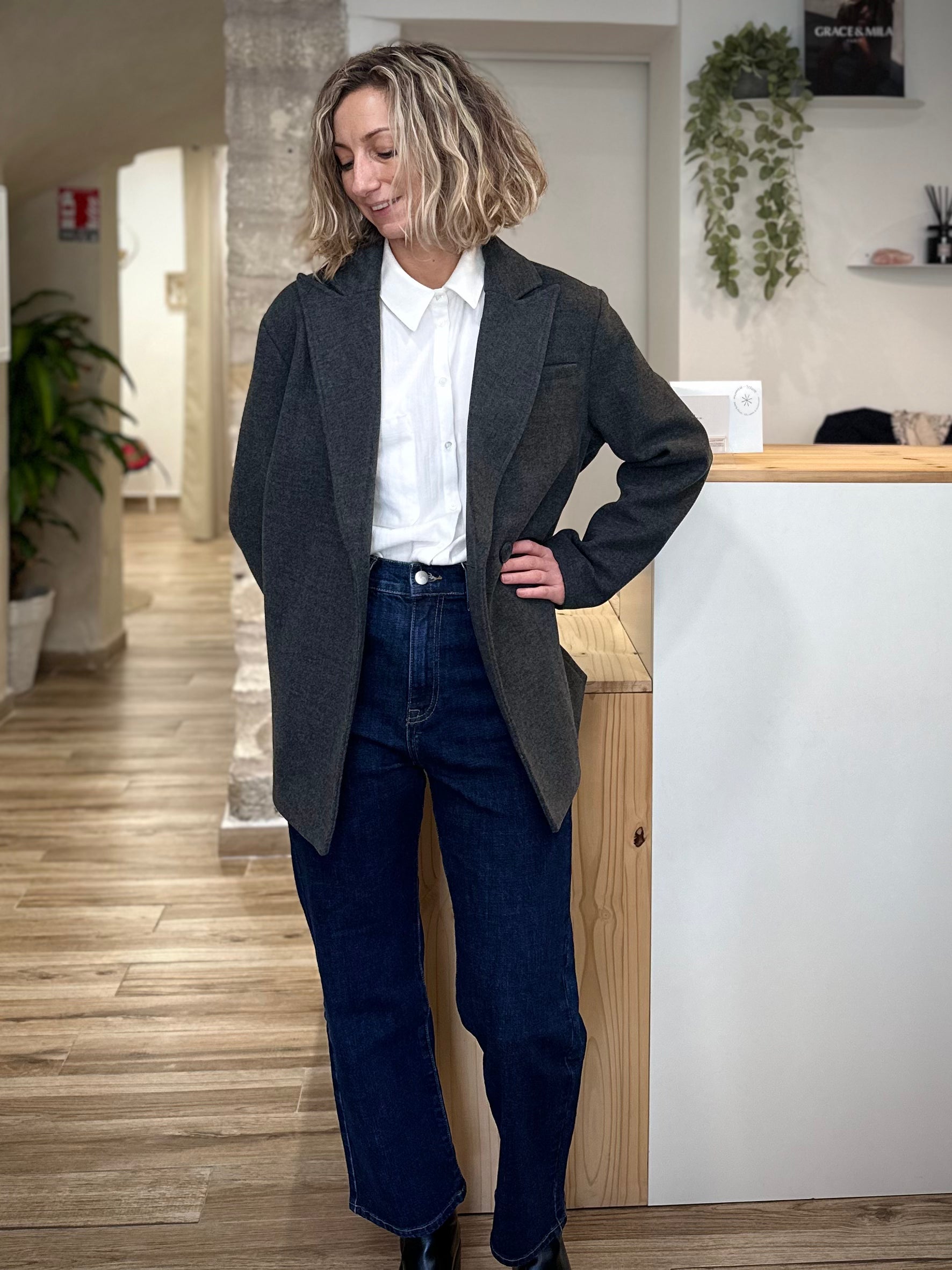 Femme en manteau gris et jean casual chic