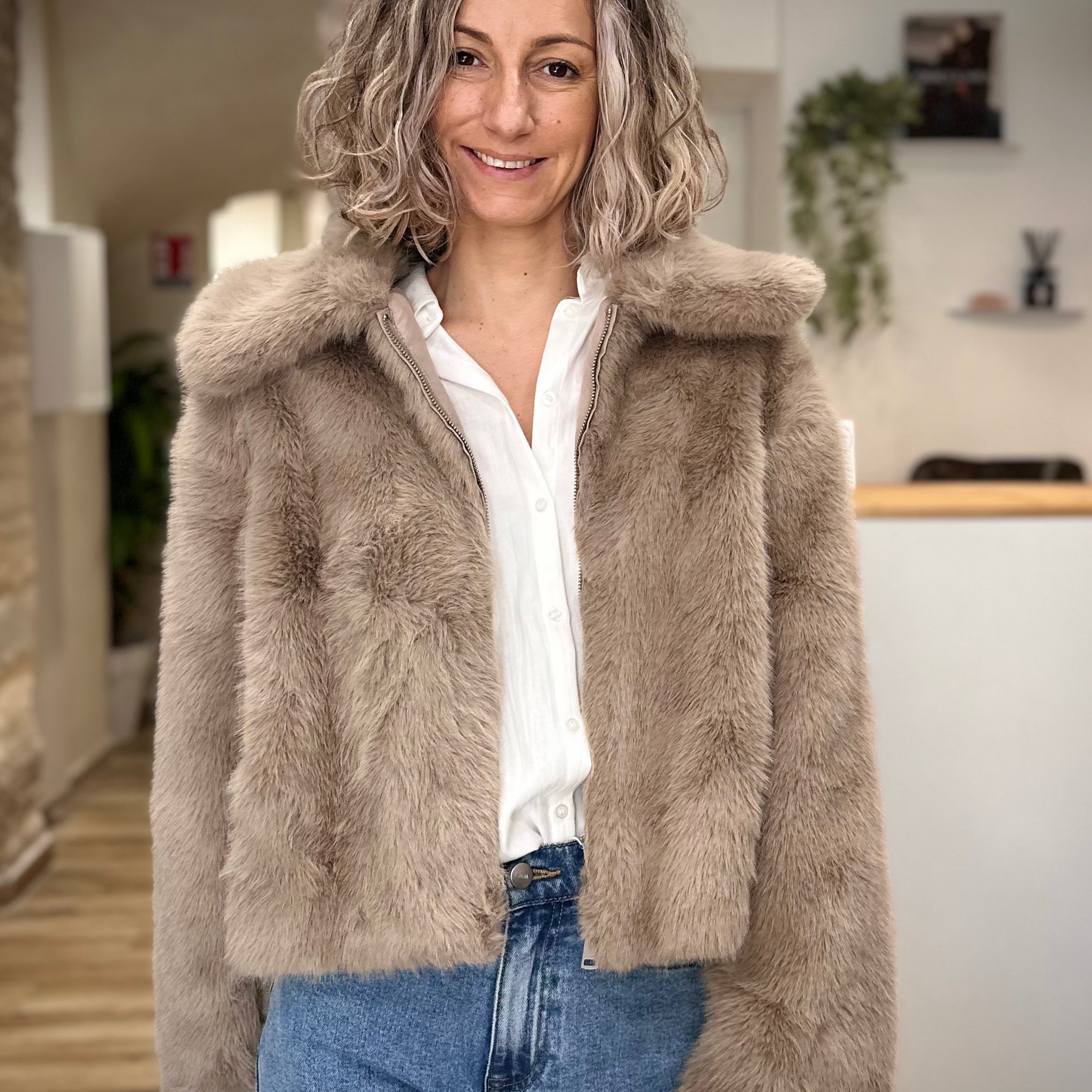 Femme portant un manteau court en fausse fourrure greige