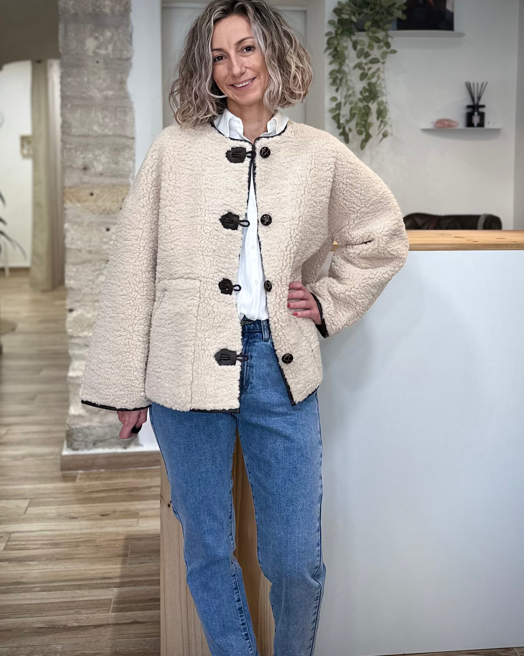 Manteau fausse fourrure écru sur jean et bottines