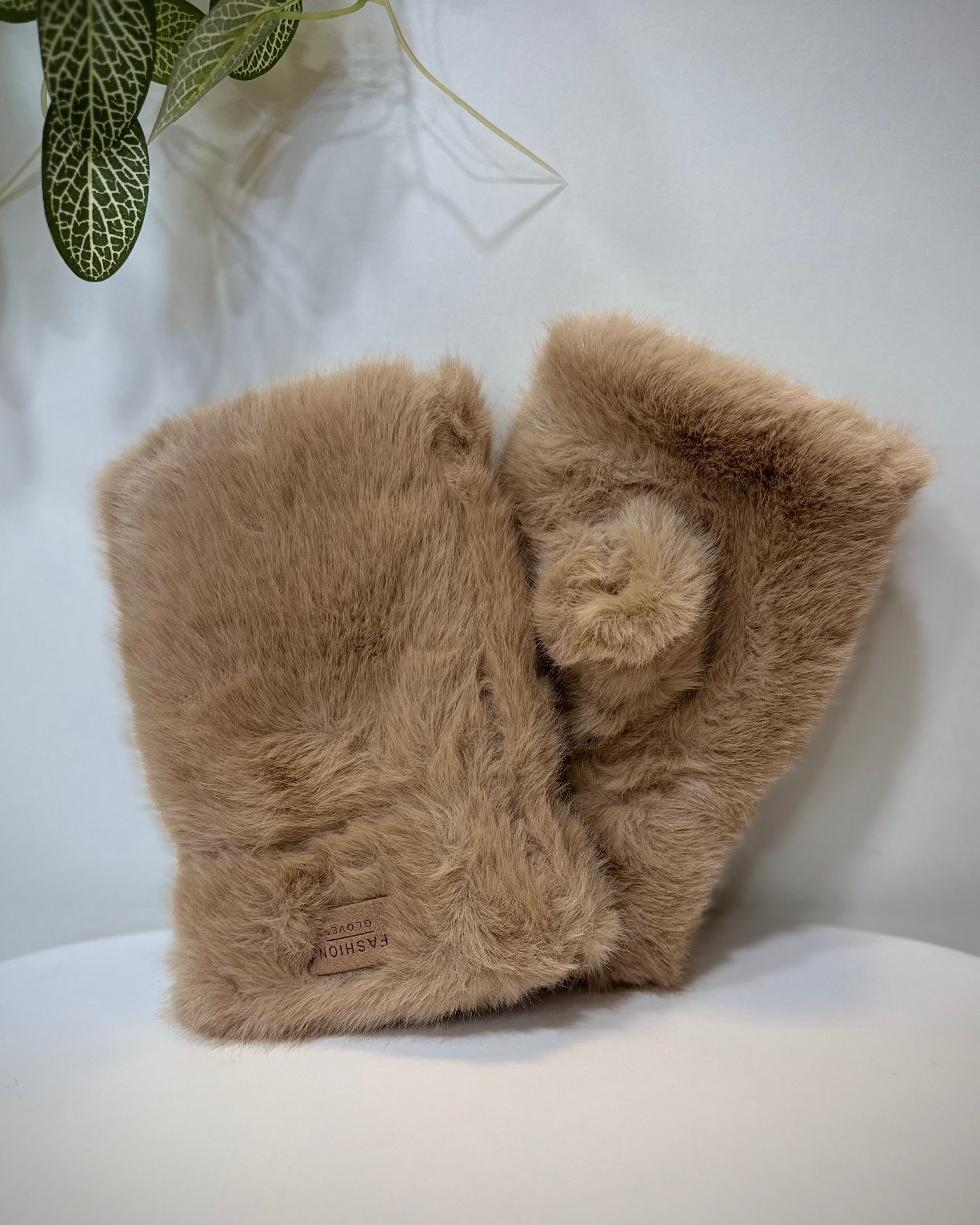 Mitaines femme fausse fourrure camel posées sur une table