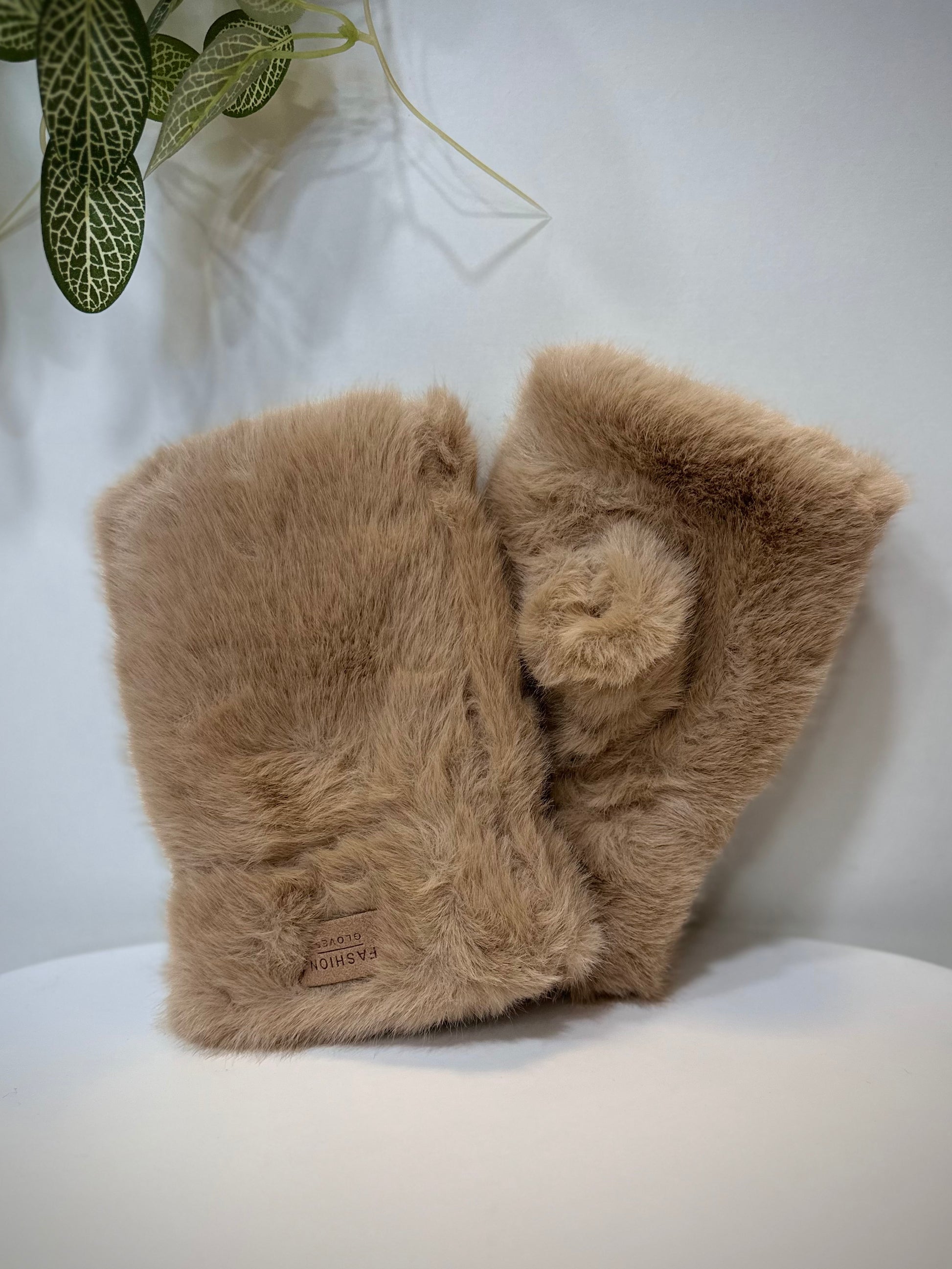 Mitaines femme fausse fourrure camel posées sur une table