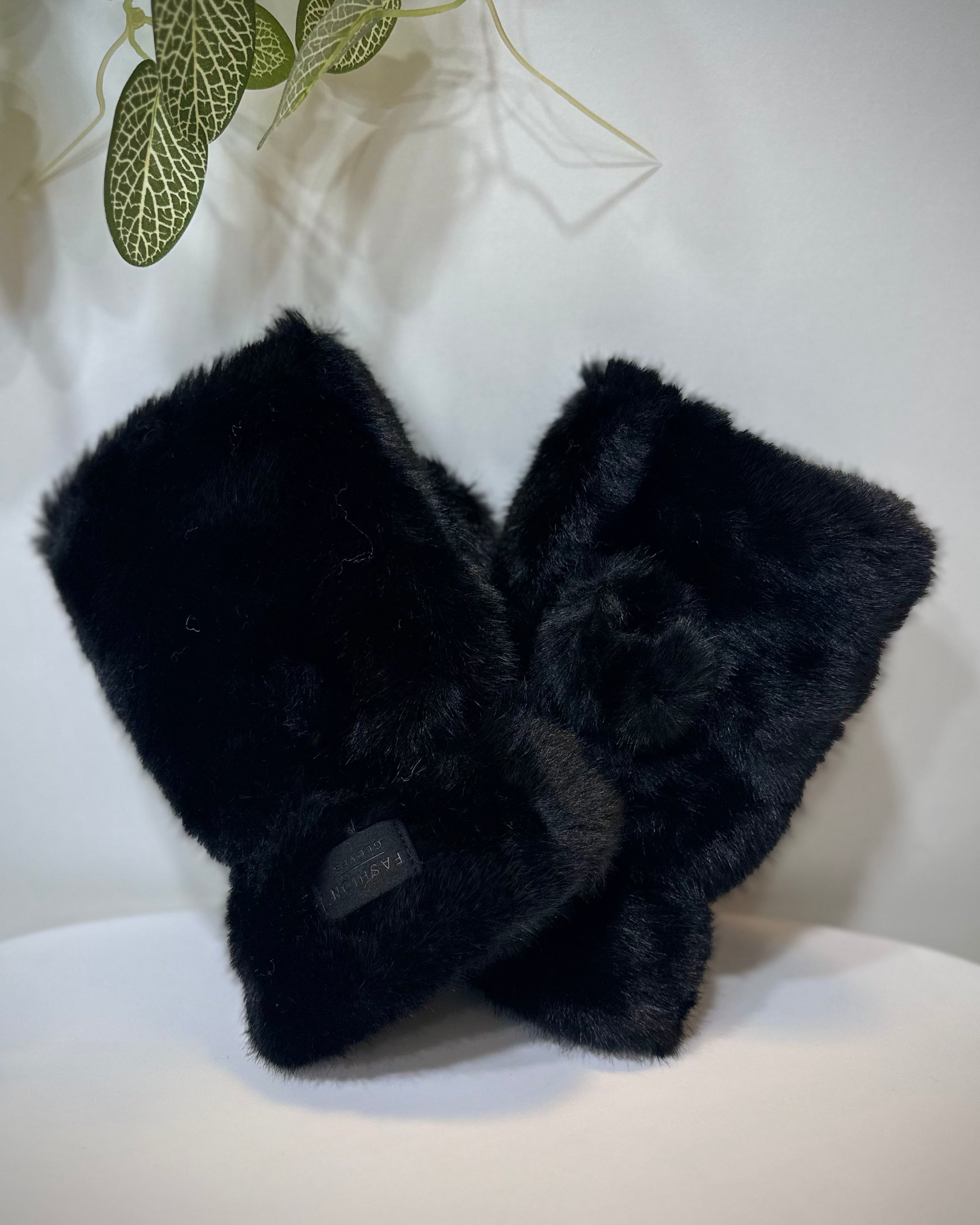 Mitaines femme fausse fourrure noires posées sur une table