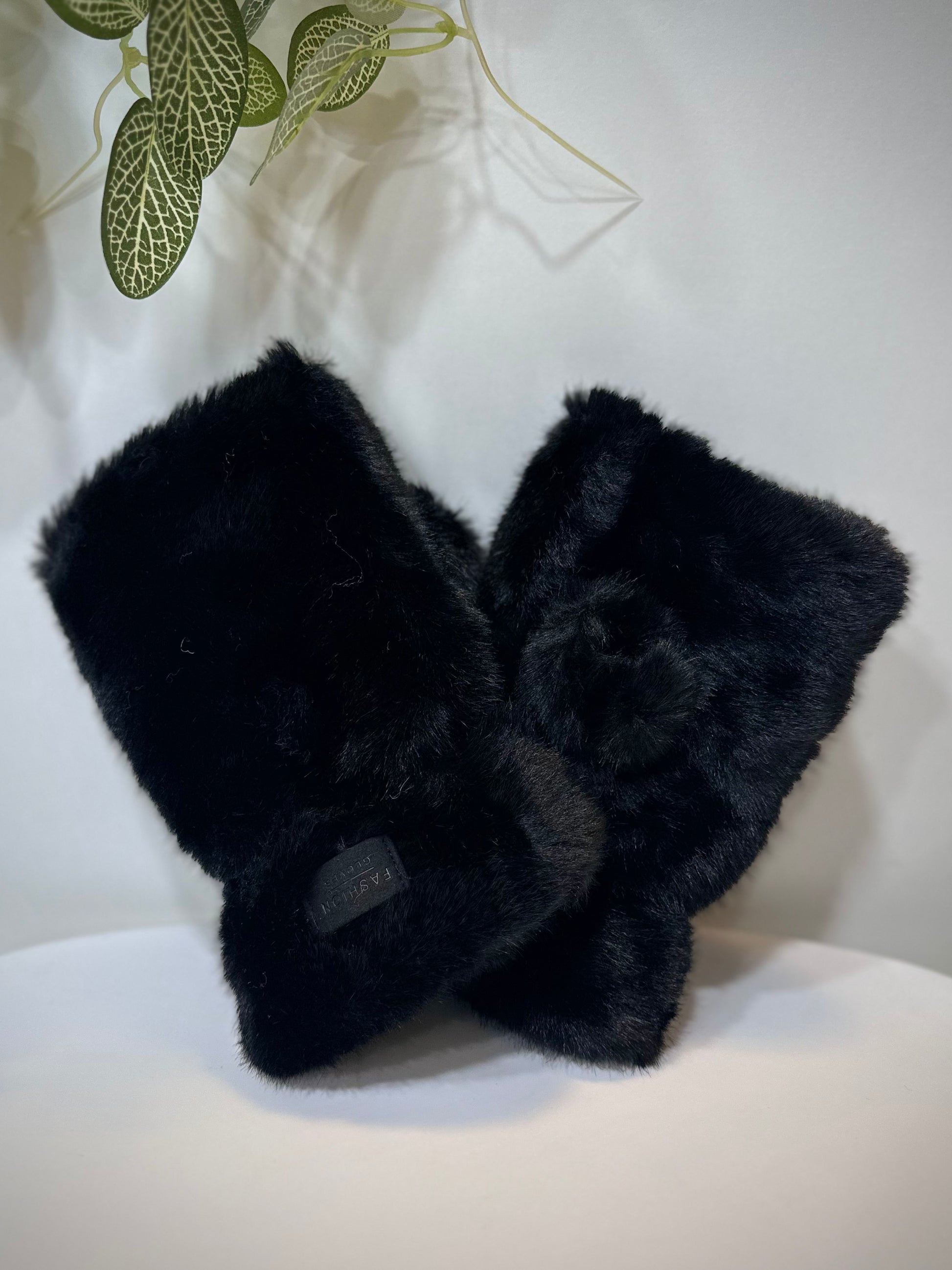 Mitaines femme fausse fourrure noires posées sur une table