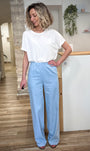 Femme portant jean évasé bleu clair taille haute fluide 