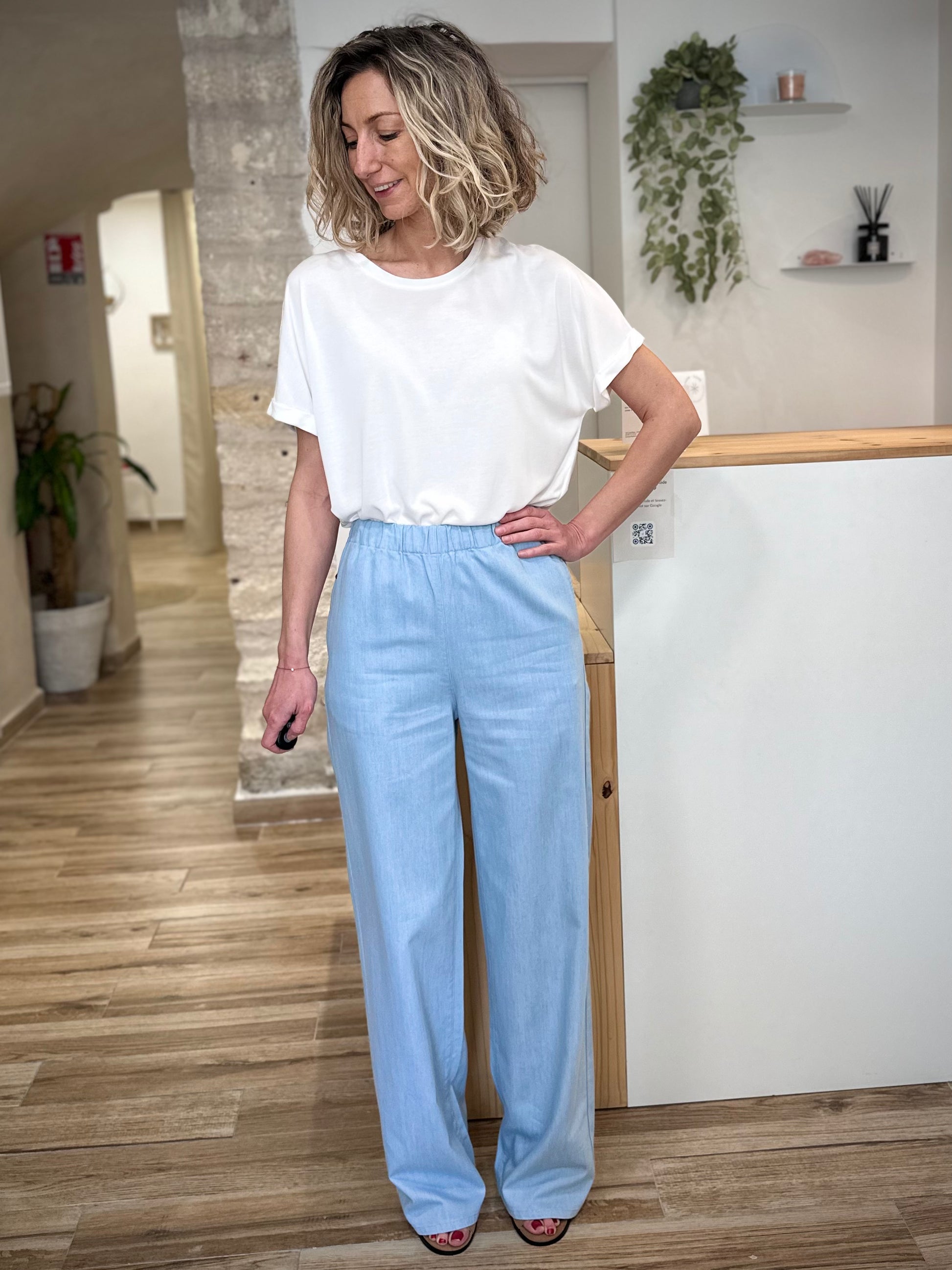 Femme portant jean évasé bleu clair taille haute fluide 
