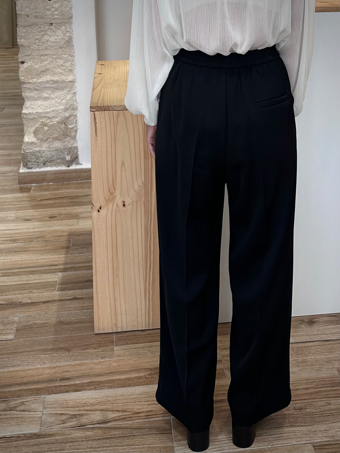 Vue arrière pantalon noir fluide avec fausse poche passepoilée